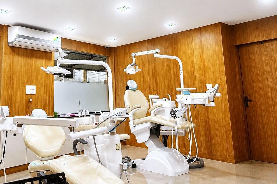 Treatment room at Smile Align Clinic with dental chair, operating light and teak wall panelling